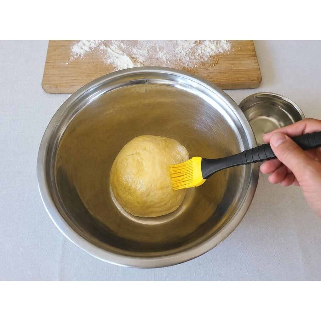 Coating the pizza dough with a little olive oil