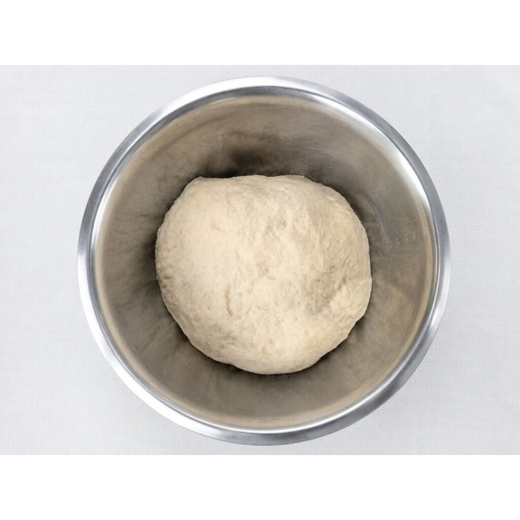 Pizza dough risen and doubled in the bowl