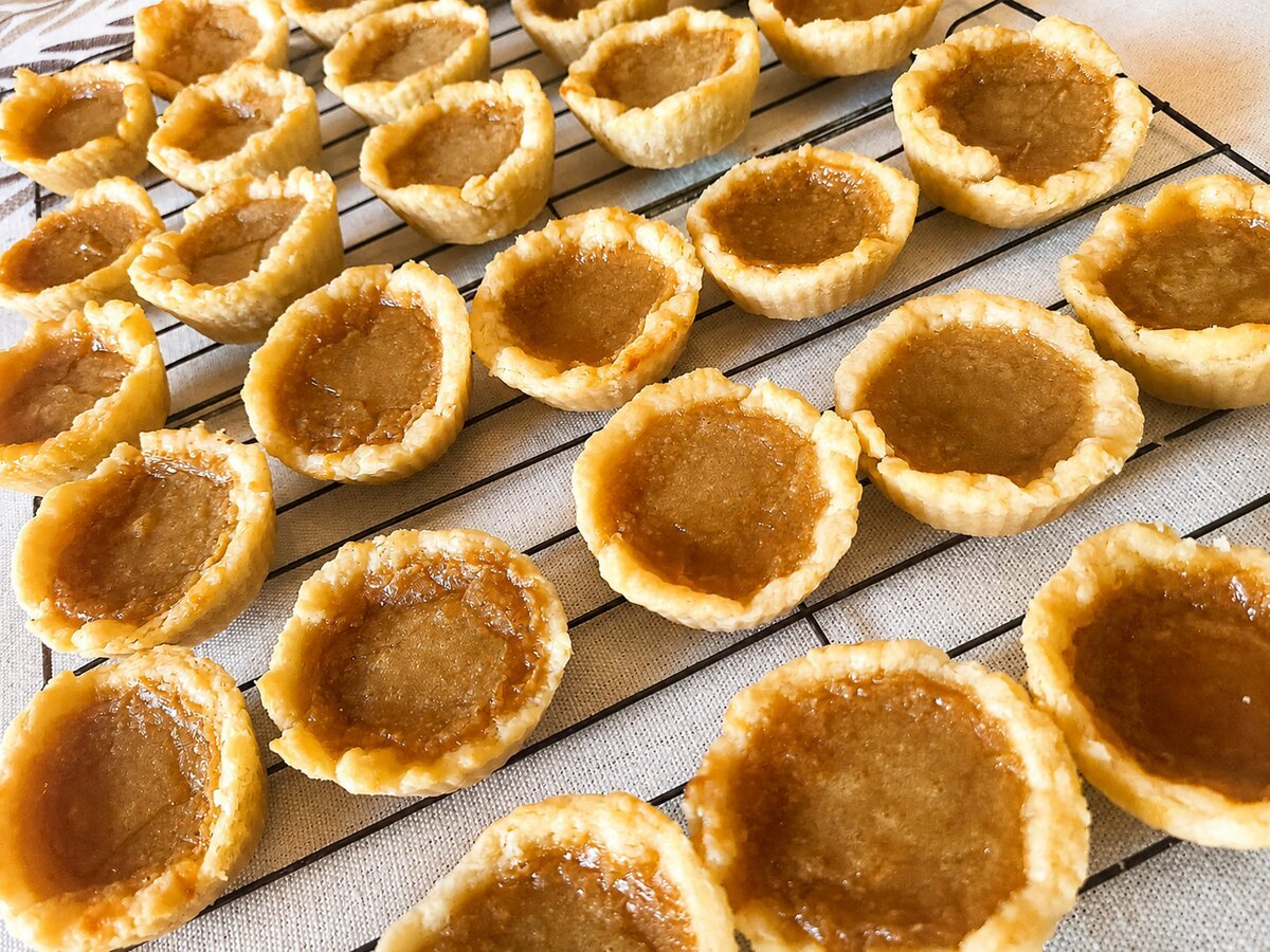 Butter tarts spread across a cooling rack, ready to share